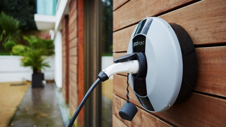 Wall-mounted electric vehicle charger installed outside a residential building